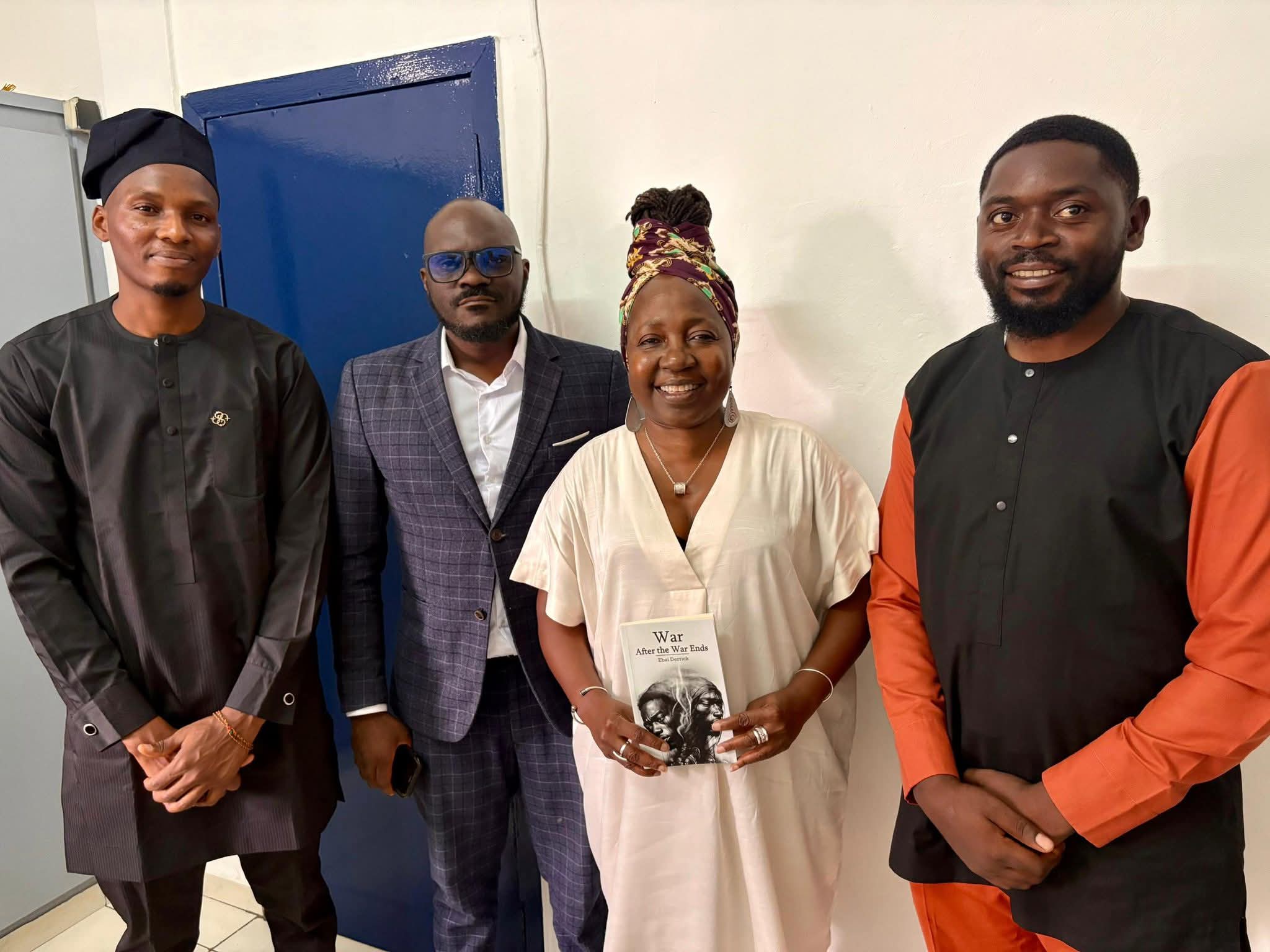 Human rights activitist Kah Walla holding an autographed copy of Ebai Derrick's novel alongside the War After the War Ends production team in Douala